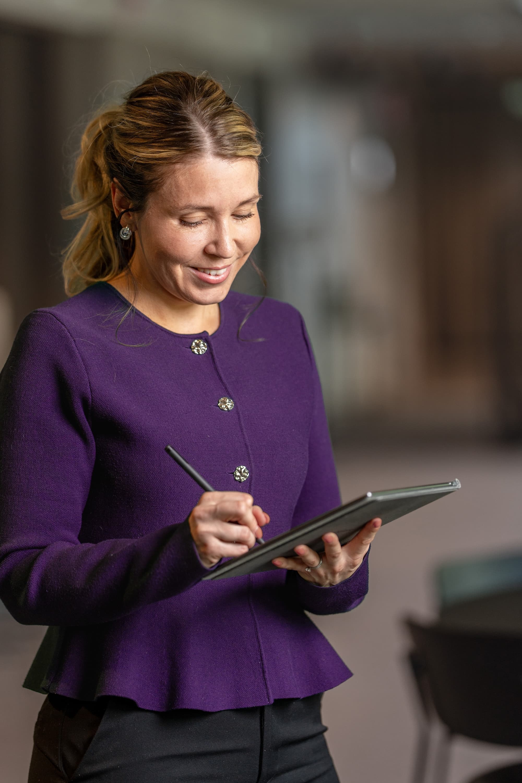 Person som leer och skriver på en digital skrivplatta. 