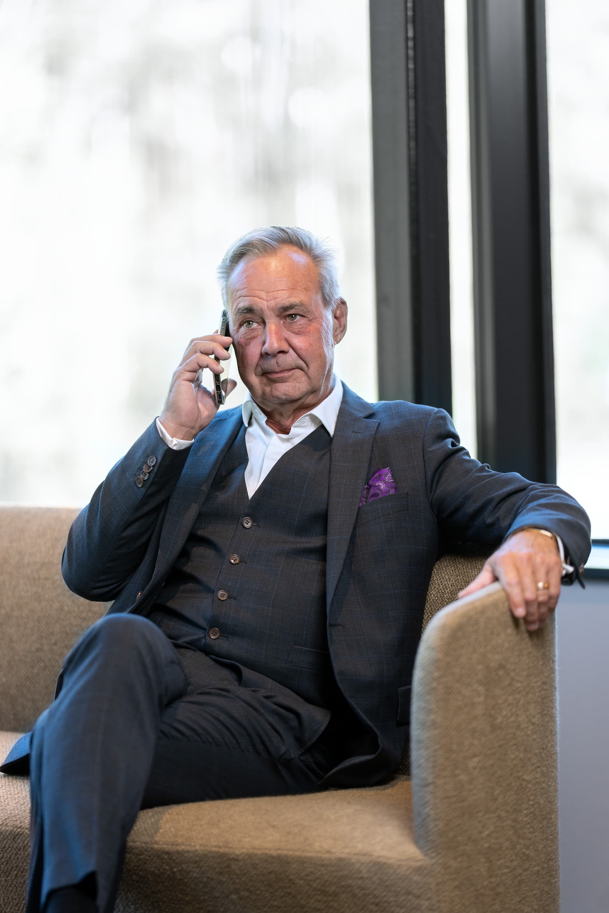 Person som sitter i soffa och pratar i telefon. 